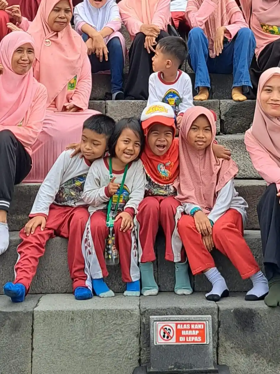 Anak-anak sekolah berfoto bersama di undakan tangga area candi saat kunjungan edukasi