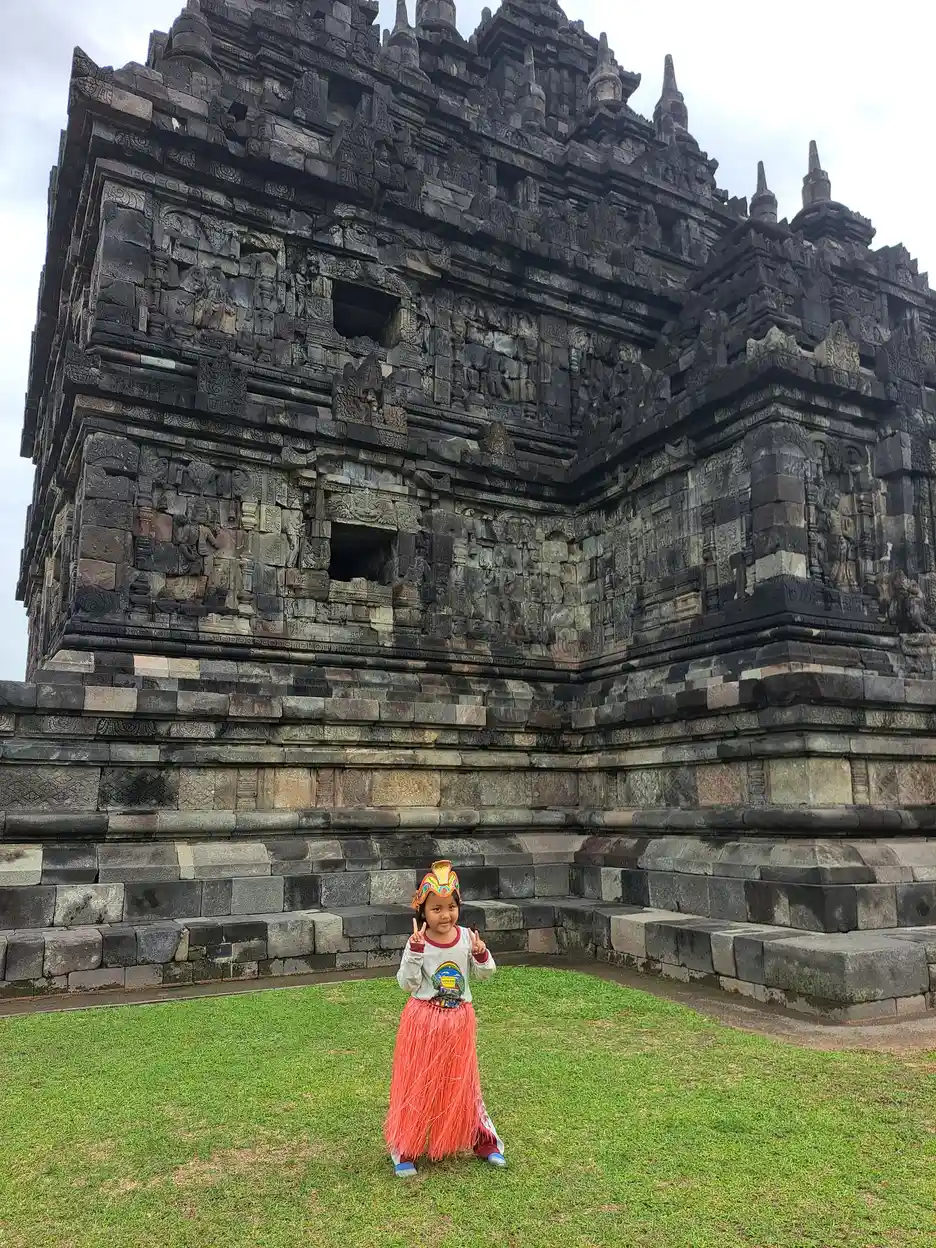 Anak berjalan menjelajah area wisata candi bersama rombongan