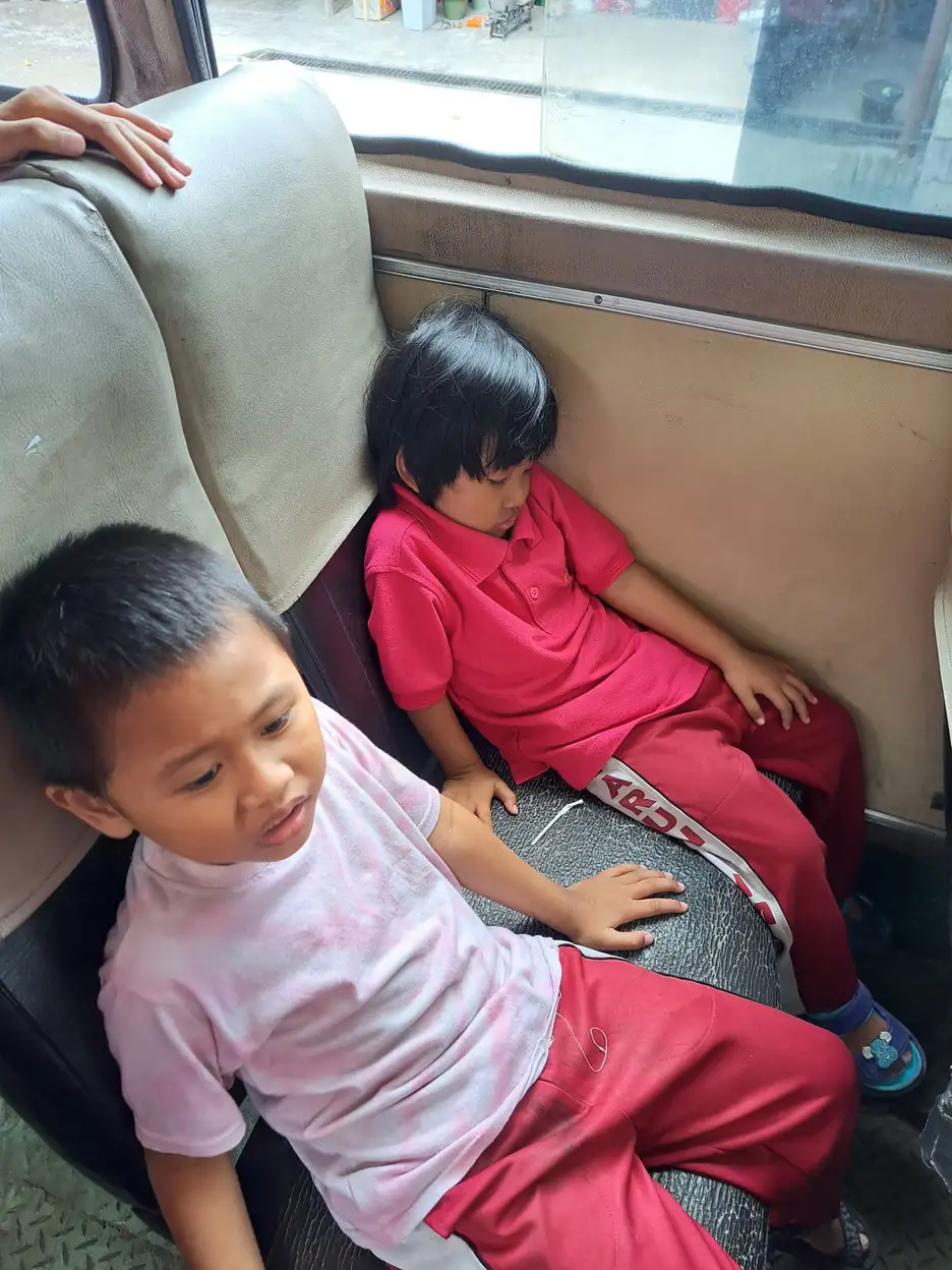 Anak-anak duduk bersama di dalam bus saat perjalanan kegiatan sekolah