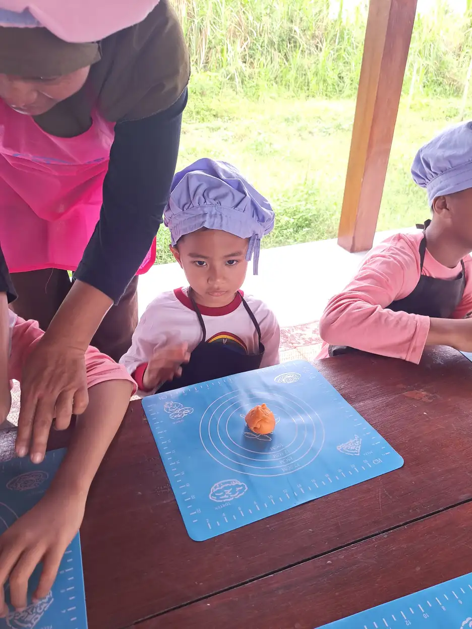 Anak berkebutuhan khusus belajar memasak didampingi oleh pendamping dewasa di YUKA