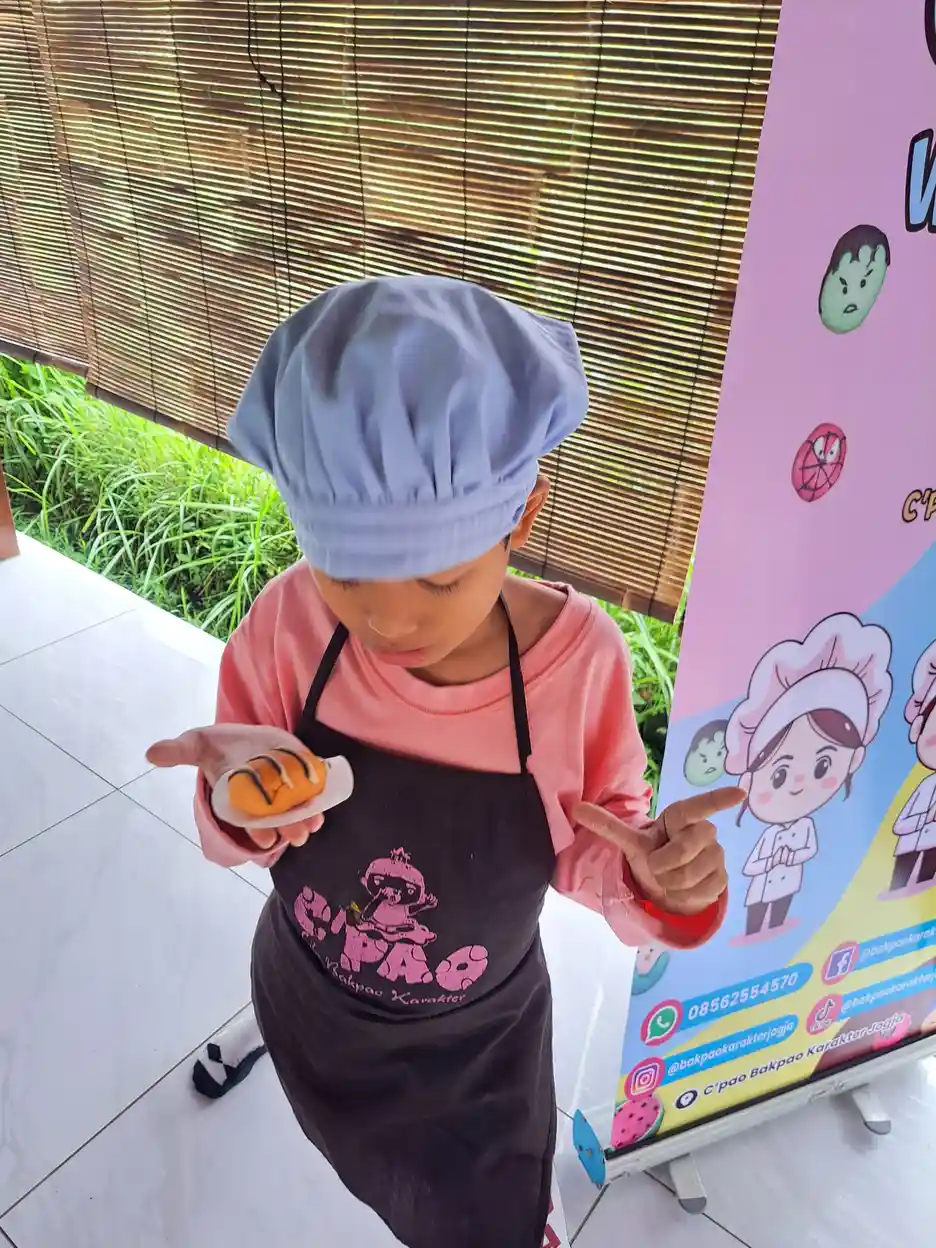 Anak berkebutuhan khusus belajar memasak dengan mengenakan celemek dan topi sebagai bentuk latihan motorik halus dan kemandirian
