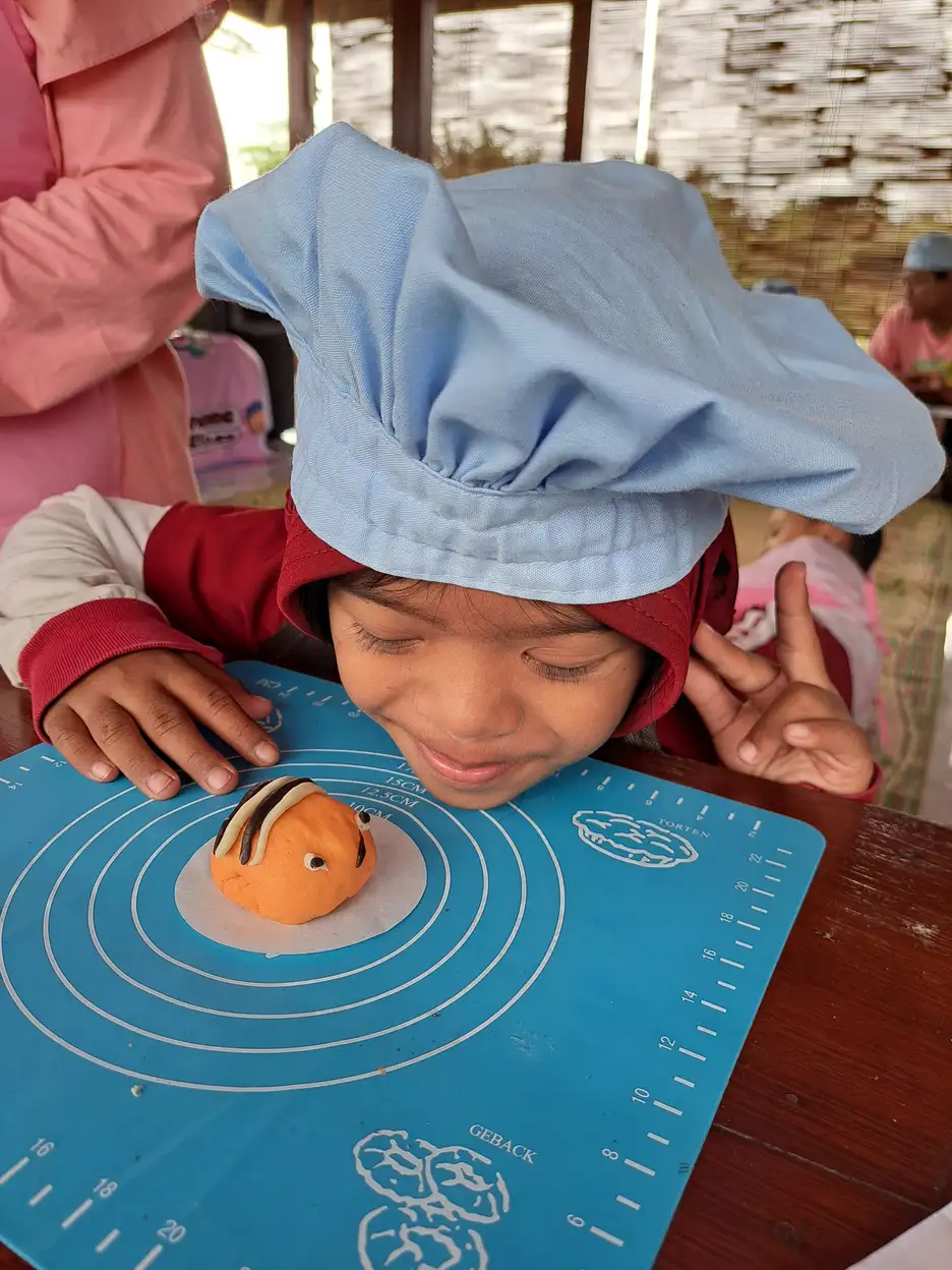 Anak sedang membentuk adonan kue sebagai latihan motorik halus di kegiatan YUKA