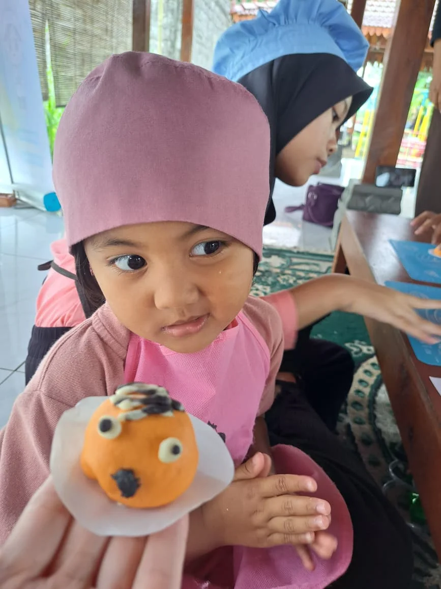 Anak-anak sedang melatih motorik halus melalui kegiatan membuat kue di YUKA, Sleman, Yogyakarta