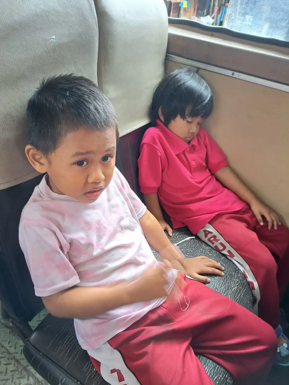 Dua anak duduk bersama di sofa, ilustrasi interaksi sosial anak berkebutuhan khusus